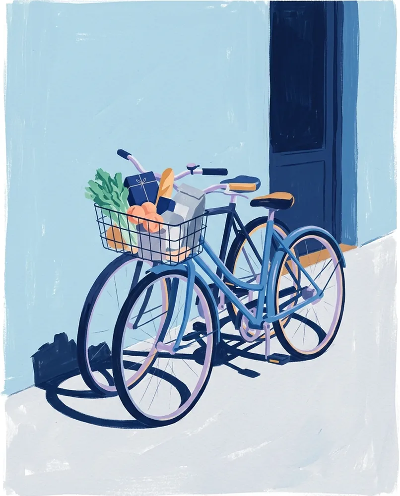 Two bicycles lean together against a painted cafe wall, with one front basket filled with groceries.