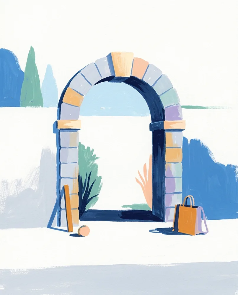 A stone arch set into a garden wall has a keystone at the top catching the sunlight.