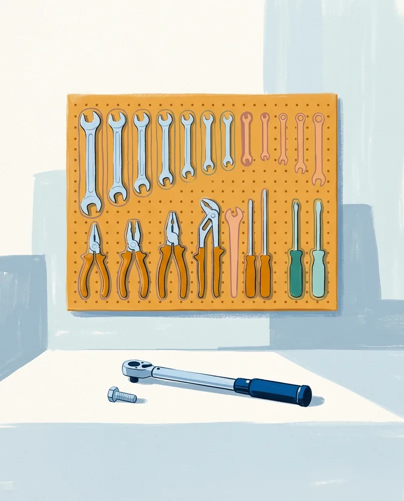 Tools hang in painted outlines on a workshop pegboard above a clean bench holding a torque wrench and one bolt.
