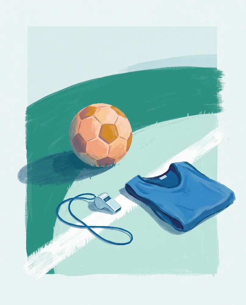 A football rests on cut grass at the end of its shadow, with a whistle and folded training bib on the touchline.
